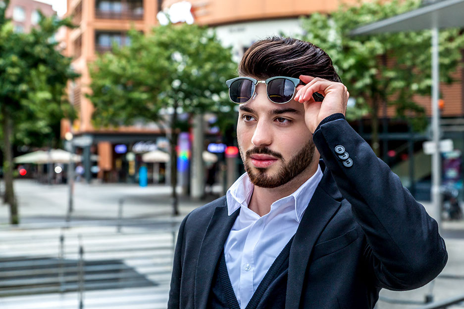Hautbildverfeinerung, Betonen der Person und Entfernung störender Elemente. Evren steht auf dem Potsdamer Platz. Bäume im Hintergrund. 