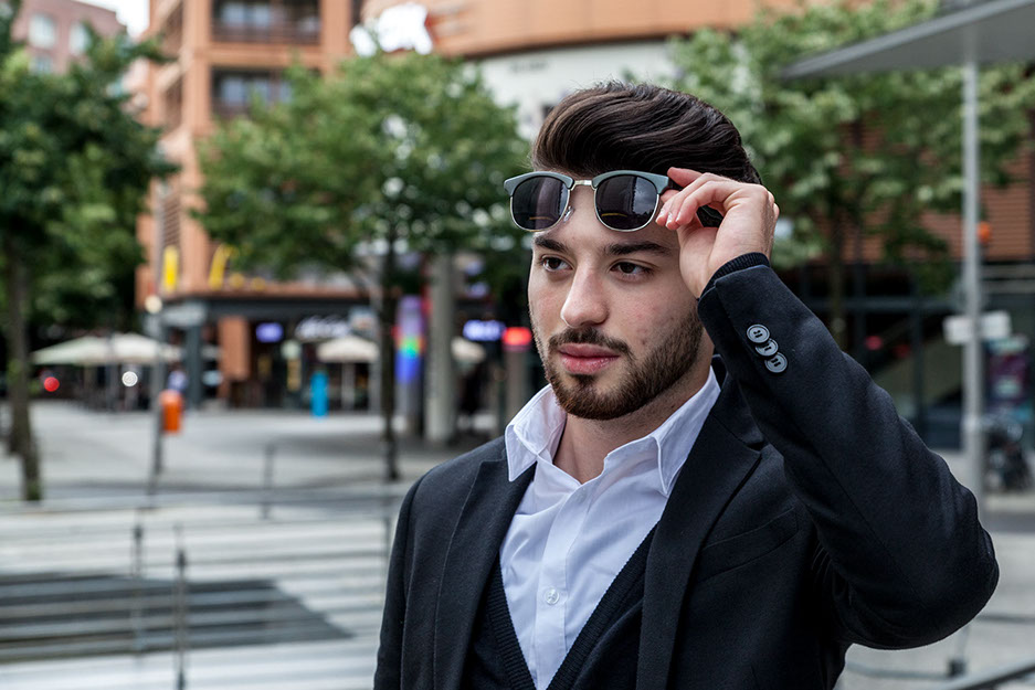 Erven Business Shooting am Potsdamer Platz. Erven hebt seine Sonnenbrille und schaut in die ferne. Vor der Bildbearbeitung.