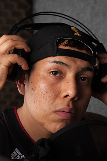 Shooting im Tonstudio. Person steht am Mirkophone und nimmt seine Kopfhörer ab. Vor der Bildbearbeitung.