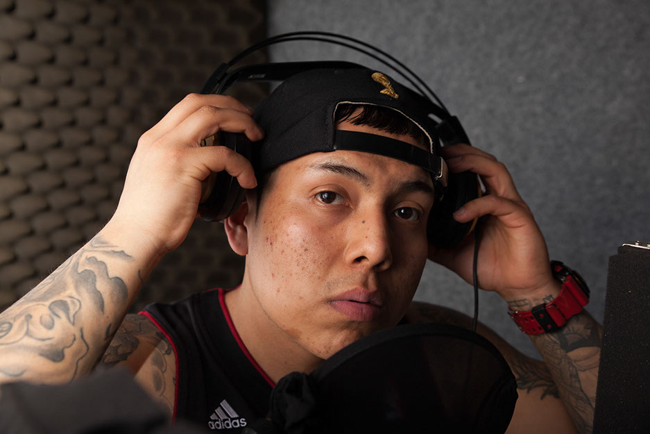 Shooting im Tonstudio. Person steht am Mirkophone und nimmt seine Kopfhörer ab. Vor der Bildbearbeitung.